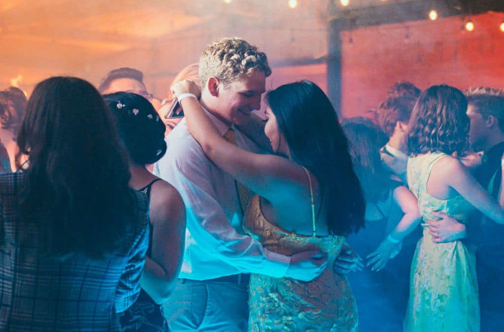 Wedding DJ performing at The Barn at Alswick with guests dancing and vibrant lighting